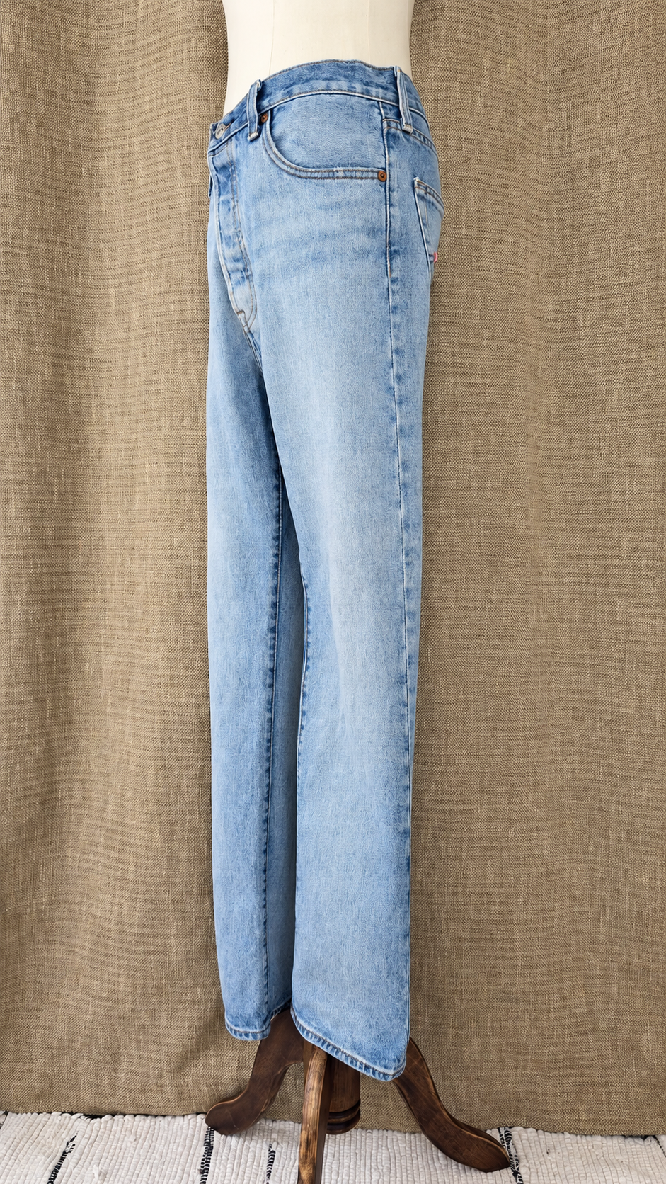 Levi's 501 light-wash jeans on mannequin, side view