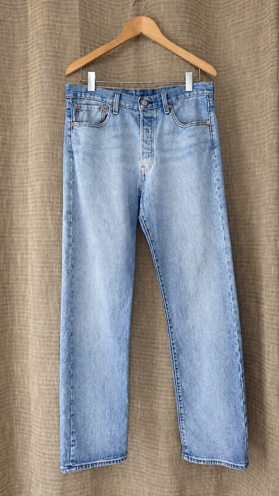 Levi's 501 light-wash jeans hanging, front view