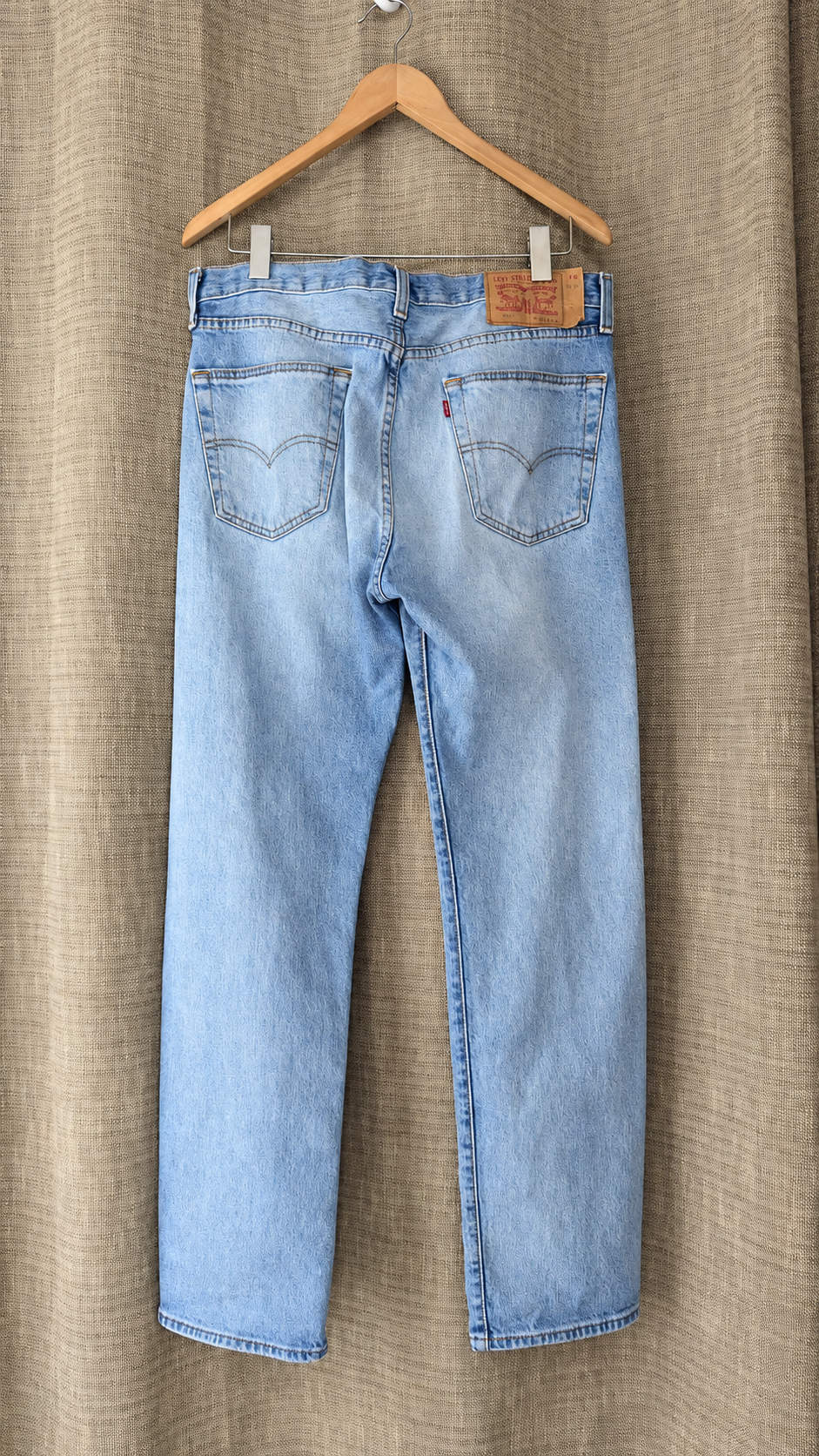 Levi's 501 light-wash jeans hanging, back view